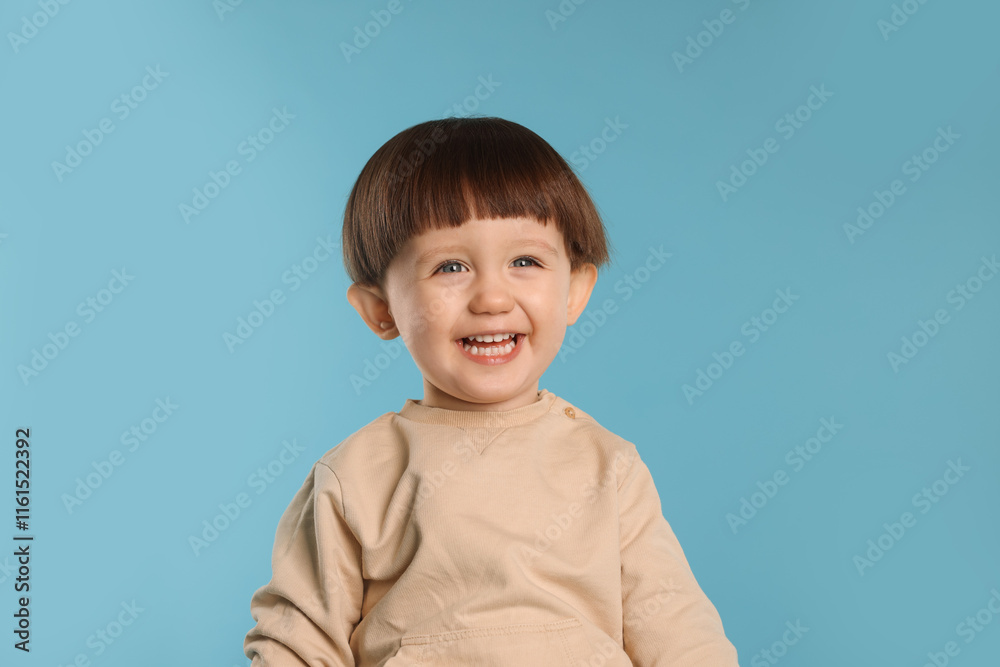 Portrait of happy little boy on light blue background Portrait of happy little boy on light blue background
