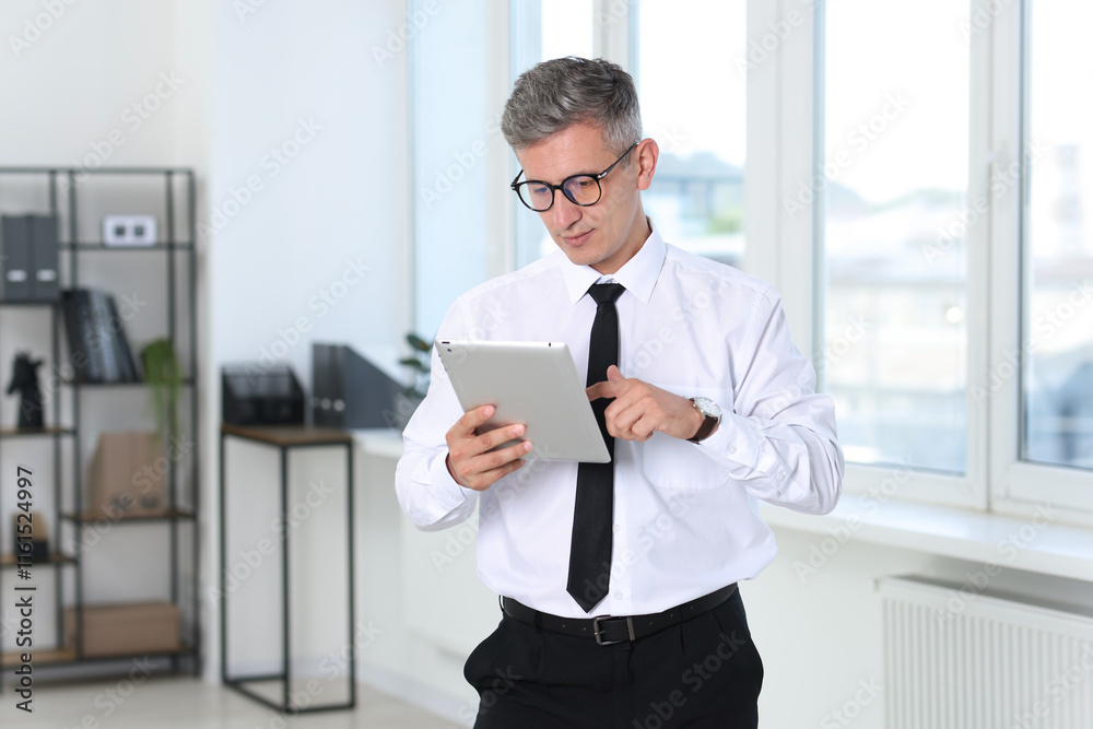 Businessman with glasses using tablet in office Businessman with glasses using tablet in office