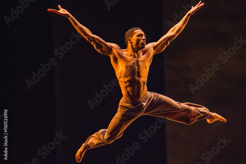 A male dancer mid-leap, arms outstretched gracefully.