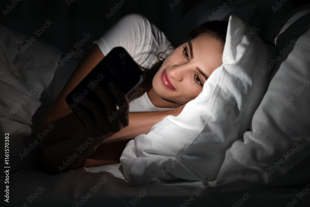 Bad habit. Young woman using smartphone in bed at night Bad habit. Young woman using smartphone in bed at night