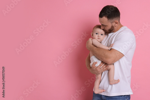 Father with his cute baby on pink background, space for text photo