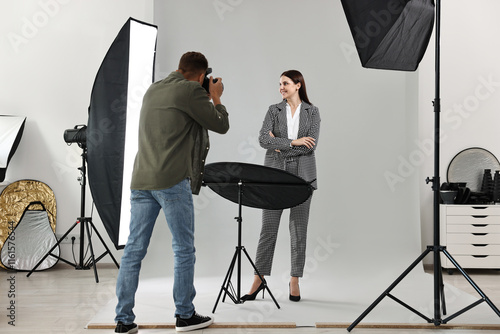 Photographer working with model in professional photo studio