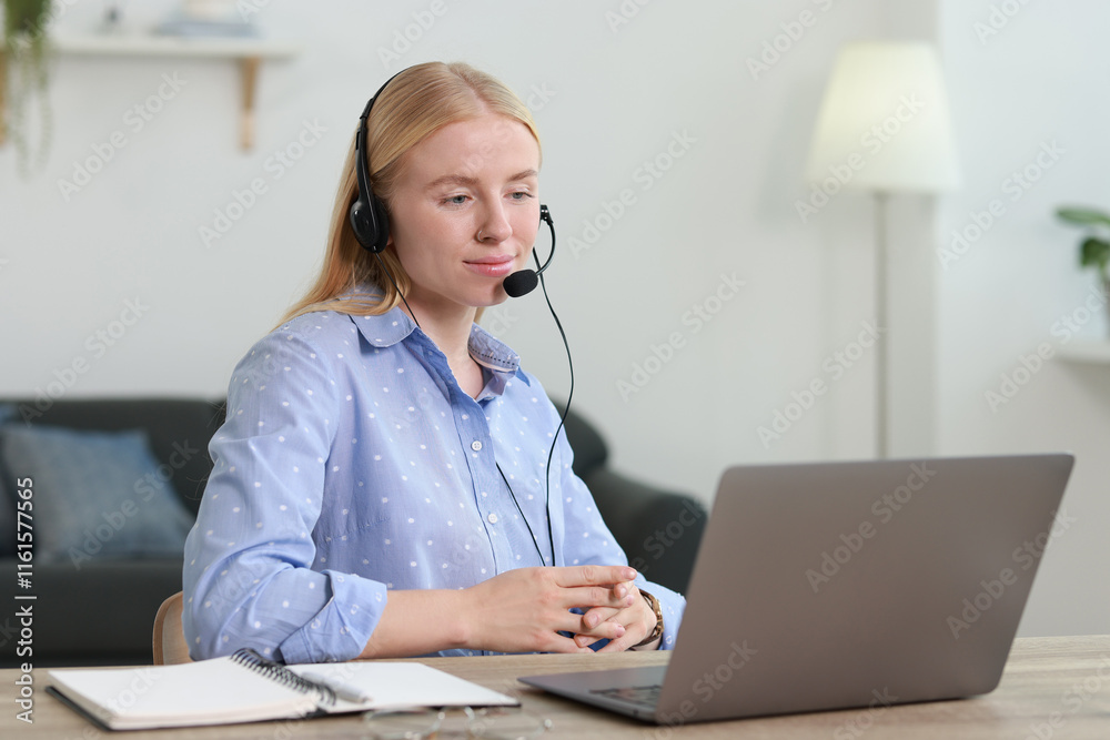 Interpreter in headset working with laptop at table indoors Interpreter in headset working with laptop at table indoors
