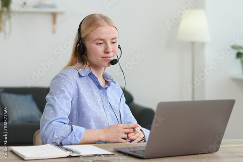 Φωτογραφία Interpreter in headset working with laptop at table indoors