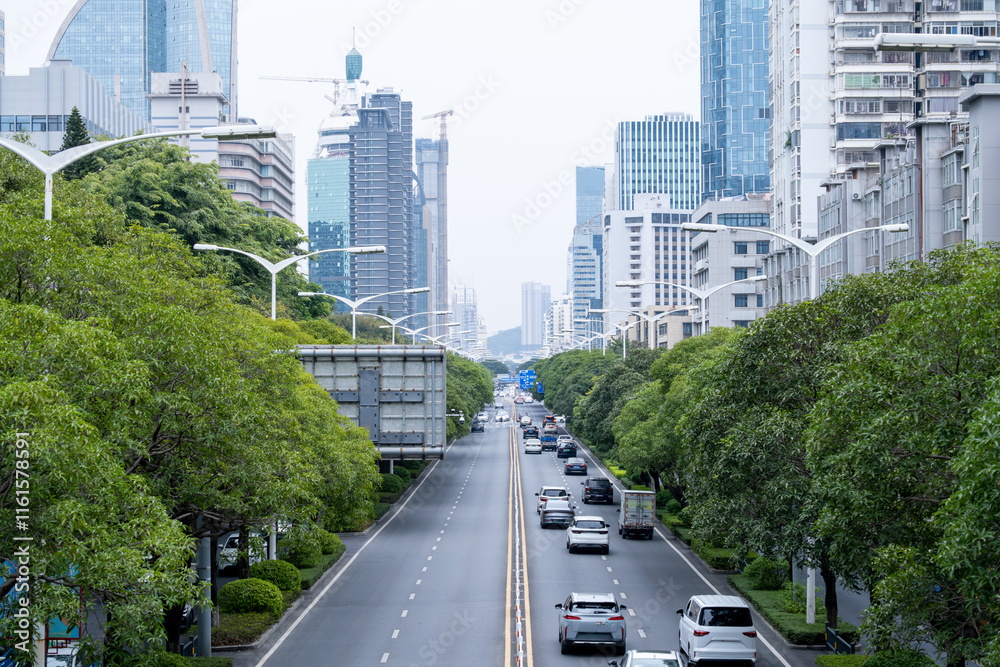 Elevated view of a modern urban boulevard in Xiamen, China, featuring a well-planned cityscape with green tree-lined streets and contemporary high-rise buildings. Elevated view of a modern urban boulevard in Xiamen, China, featuring a well-planned cityscape with green tree-lined streets and contemporary high-rise buildings.