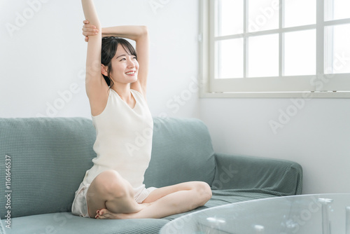 家のソファでリラックス・リフレッシュをする若いアジア人女性（モーニングルーティーン）
 photo