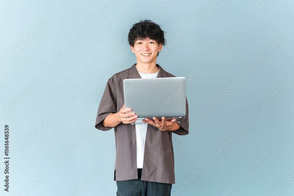 パソコンを持つデジタルネイティブ世代の若い男性
パソコンを持つデジタルネイティブ世代の若い男性