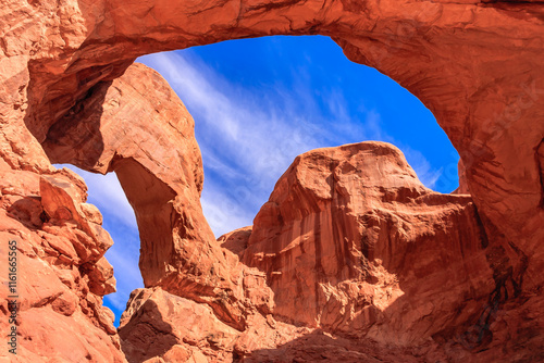 Valokuva A large archway in a canyon with a blue sky above