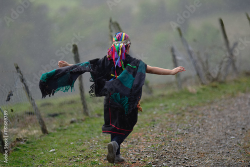 Joven etnia Mapuche, corriendo libremente en un campo con los brazos abiertos.  photo