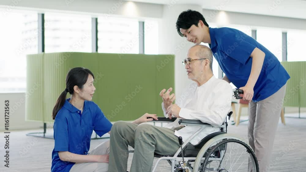 介護士と話をする車椅子の高齢者 介護士と話をする車椅子の高齢者