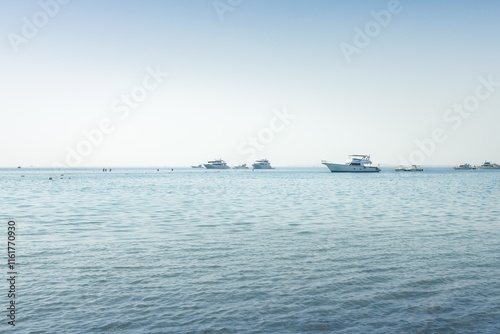 Exploring the tranquil waters of the Egyptian Red Sea with boats and swimmers on a calm afternoon