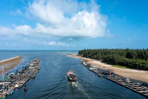 Fishing boat harbor in Paihang Village of Boao showcases serene waters and lush greenery on a sunny day photo