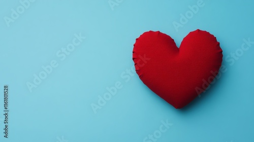 Red fabric heart on a blue background symbolizing love and affection.