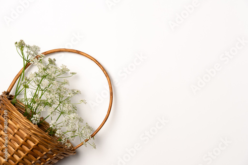 Wild flowers in a wicker basket on a white background. Flat lay, top view. Copy space