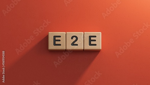 text E2E is written on wooden cubes standing in a row. around the blocks with letters. can be used for business and financial concepts. selective focus.3D rendering on red background. photo