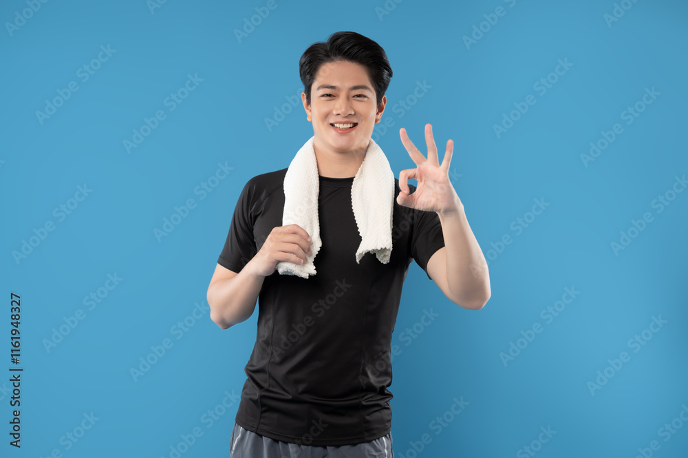 Portrait of young Asian man wearing gym clothes posing on blue background Portrait of young Asian man wearing gym clothes posing on blue background