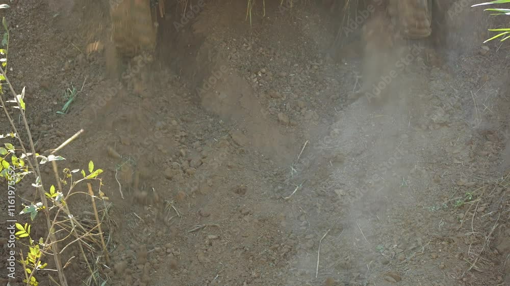 Close-up of wheels slipping on a steep slope. An SUV kicks up a cloud of dust as it drives uphill. Tires with aggressive treads dig into the ground, throwing it out from under them. Slow motion Close-up of wheels slipping on a steep slope. An SUV kicks up a cloud of dust as it drives uphill. Tires with aggressive treads dig into the ground, throwing it out from under them. Slow motion