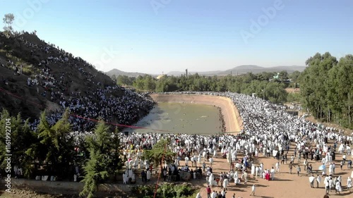 Thousands of Ethiopian people at Timkat parade- Aerial Footge 
Drone view over Large crowd parade dressed in white clothes Ethiopian Timkat Ceremony Ending, Ethiopia,19.1.2020
 photo