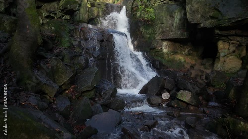 Drone view of Lumsdale falls streaming on rocks in a steep-sided gorge in Derbyshire, England