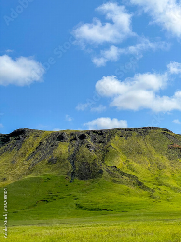 Vibrant green mountain under a clear blue sky photo