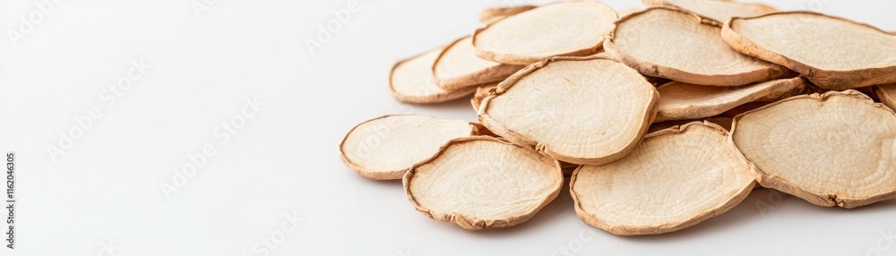 A pile of thin, light-colored potato slices arranged on a white surface, showcasing their natural texture and shape. A pile of thin, light-colored potato slices arranged on a white surface, showcasing their natural texture and shape.