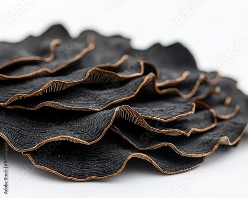 A close-up of textured, wavy black fabric, showcasing intricate layers and stitching, highlighting craftsmanship and material quality.