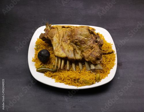 Deep marinated coocked mutton rib Majboos rice in a white ceramic plate in a dark background