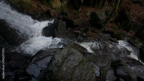 Lumsdale falls streaming on big rocks in a steep-sided gorge in Derbyshire, UK