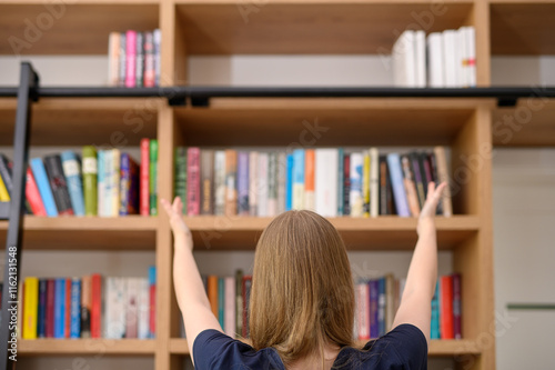 Wyciągnięte ręce w stronę biblioteczki z książkami, wiedza i  wykształcenie koncept photo