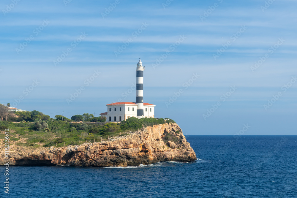 Portocolom lighthouse dominating the rocky coast of mallorca island Portocolom lighthouse dominating the rocky coast of mallorca island