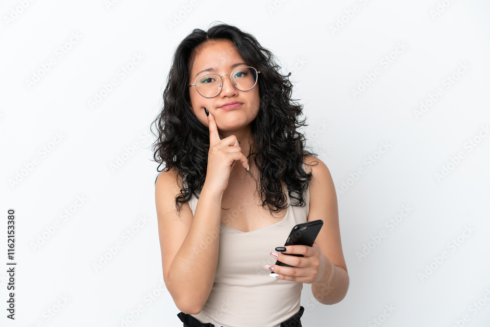 Young asian woman isolated on white background using mobile phone and thinking Young asian woman isolated on white background using mobile phone and thinking