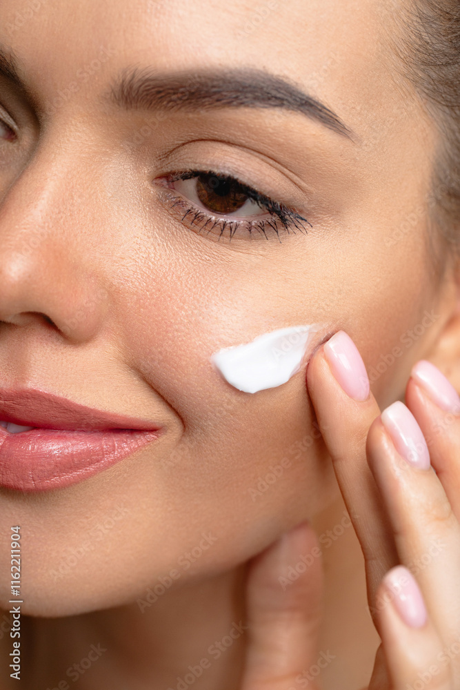 Cream smear. Beauty close up portrait of young woman with a healthy skin is applying a facial skincare product. Face daily care routine Cream smear. Beauty close up portrait of young woman with a healthy skin is applying a facial skincare product. Face daily care routine