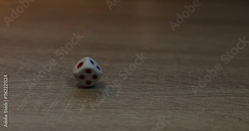 The dice are rolling across the table. Slow motion video