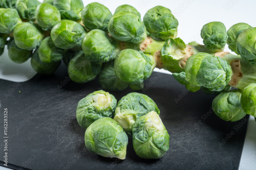 Green brussels sprouts on stalk on white table Green brussels sprouts on stalk on white table
