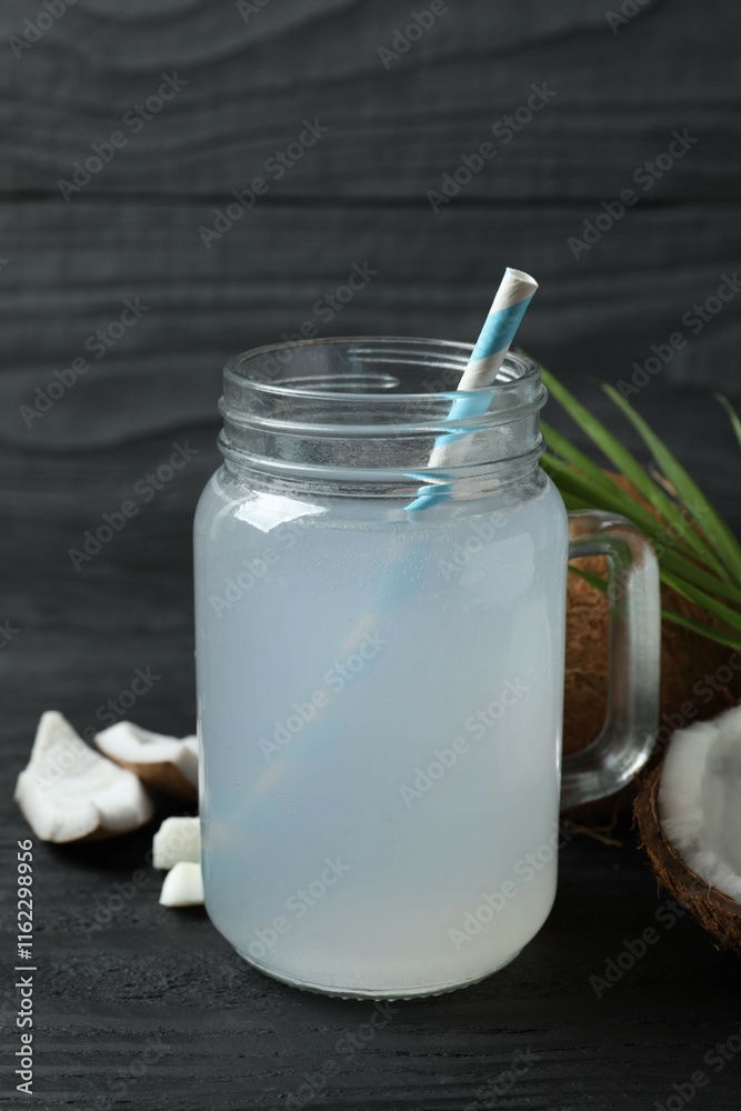 Mason jar with coconut water with nuts on wooden table Mason jar with coconut water with nuts on wooden table