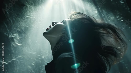 Woman with flowing hair illuminated by light in a misty forest at night during a contemplative moment