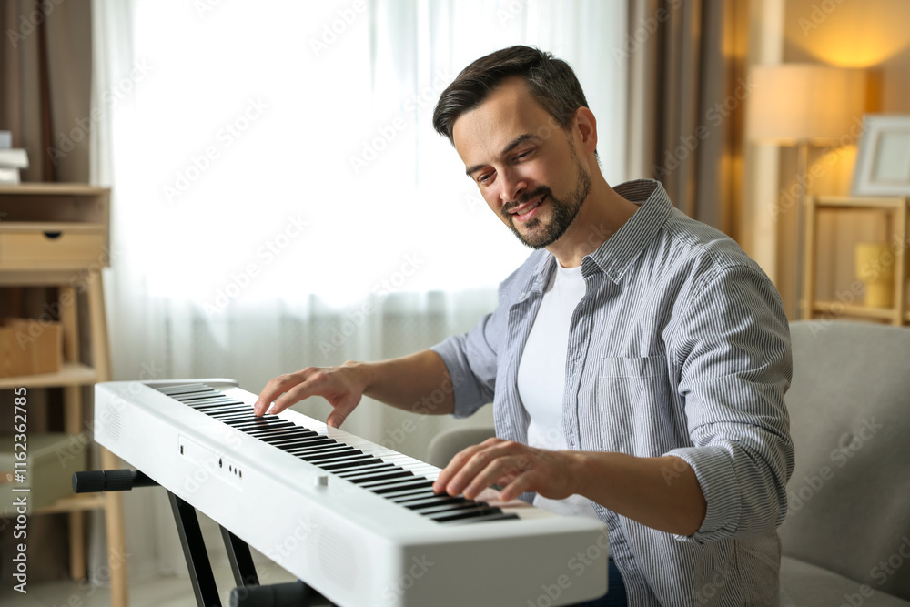 Fototapeta premium Man playing synthesizer at home. Electronic musical instrument