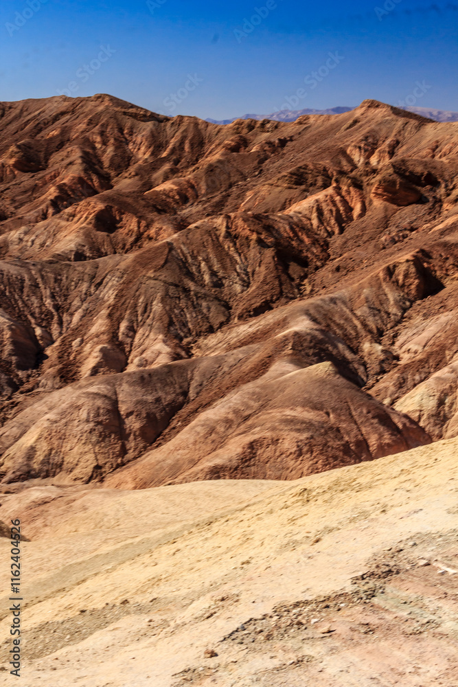Fototapeta premium A mountain range with a blue sky in the background