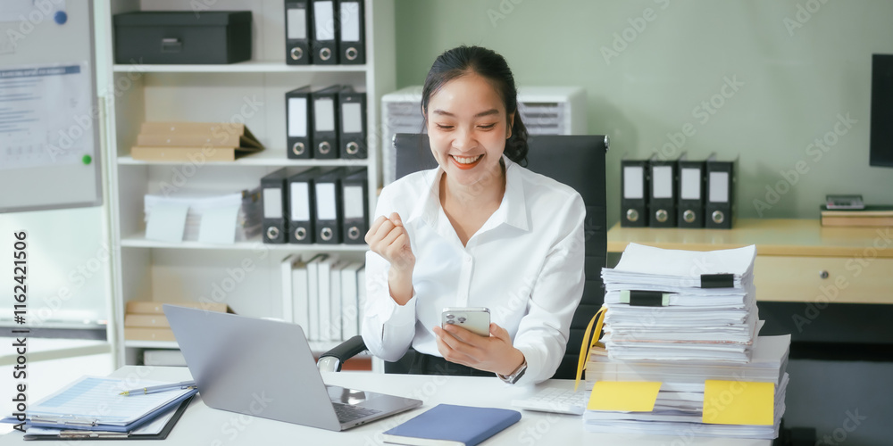 An Asian businesswoman sits at her desk in the office, working on her laptop, checking documents, and planning business strategies to enhance productivity and achieve professional goals An Asian businesswoman sits at her desk in the office, working on her laptop, checking documents, and planning business strategies to enhance productivity and achieve professional goals