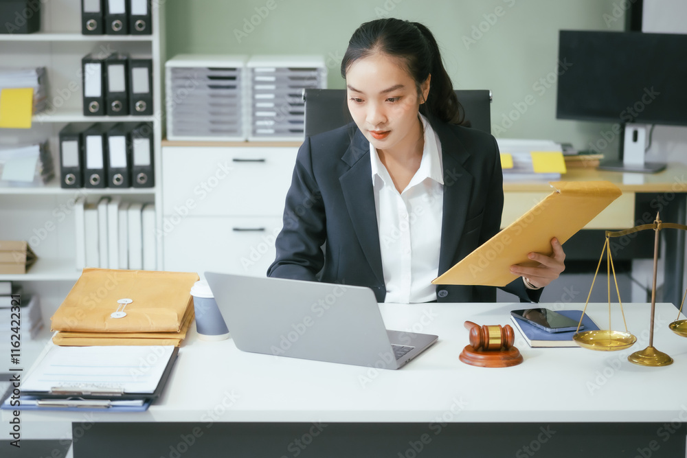 An Asian female lawyer sits at her desk in a modern law office, examining documents meticulously. She shows professionalism and dedication while consulting online and offering legal advice, justice An Asian female lawyer sits at her desk in a modern law office, examining documents meticulously. She shows professionalism and dedication while consulting online and offering legal advice, justice