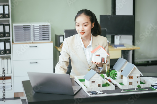 An Asian female staff member sells houses online, discussing project homes, loans, and contracts.She guides buyers and sellers through the process of purchasing and selling house and land properties photo