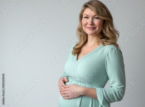 Pregnant woman in mint dress on white background, perfect for maternity and pregnancy related concepts photo