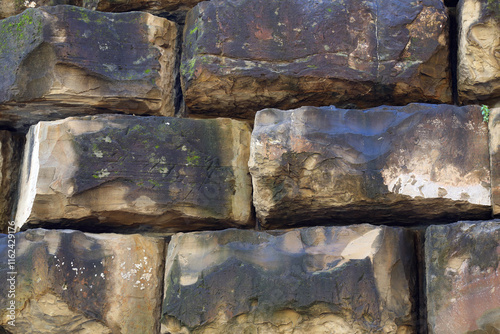 A fragment of a wall made up of large blocks of stone photo