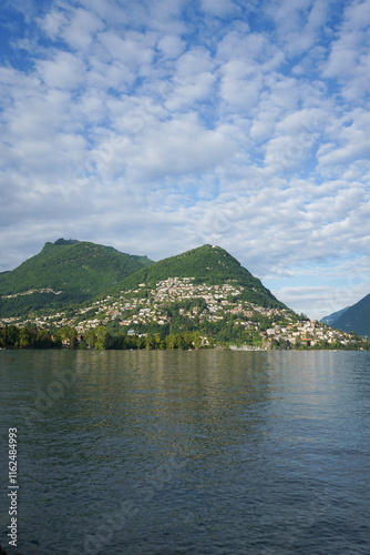 View of Monte Bre (mountain Bre) and Monte Boglia (mountain Boglia) across Lugano lake and a corner of Lugano city houses, in Lugano, Switzerland photo