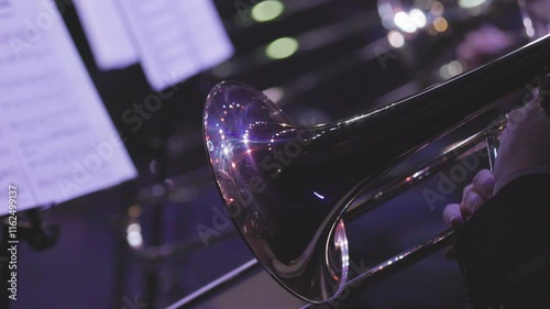 A musician playing a trombone during a live jazz performance in dim lighting