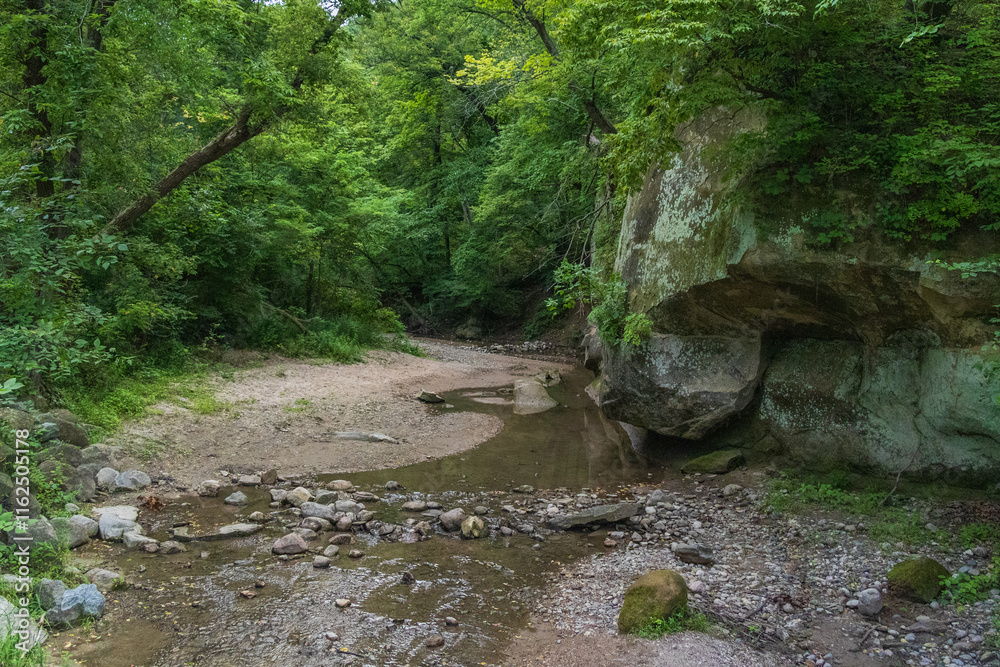 Shallow creek with large sandbar wandering along a natural stone wall in the woods in Iowa; concept of outdoor adventures, and tranquility
Shallow creek with large sandbar wandering along a natural stone wall in the woods in Iowa; concept of outdoor adventures, and tranquility