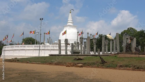 Ruins of a Buddhist temple on the background of the ancient Dagoba Thuparama. Anuradhapura, Sri Lanka