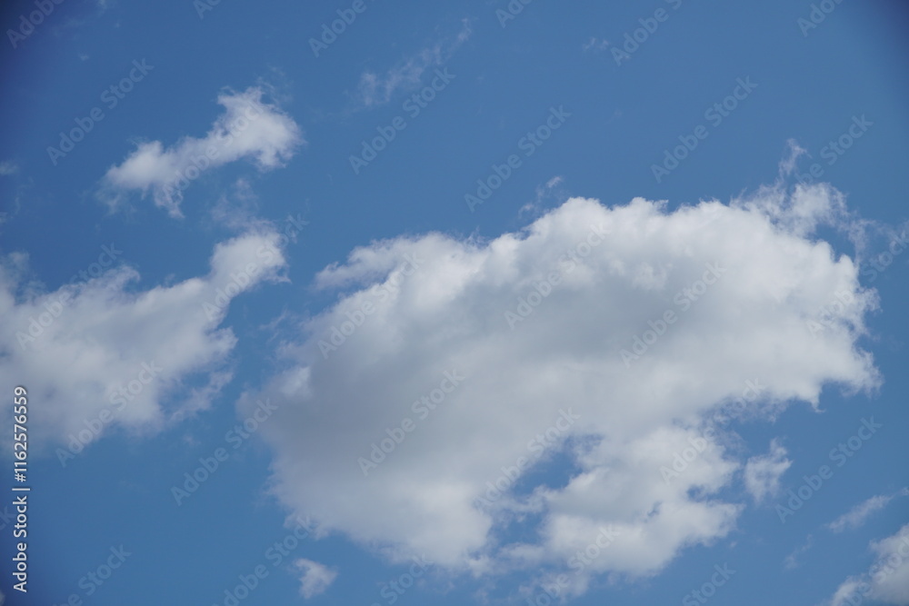 Clear blue sky with a few clouds. The sky is very bright and the clouds are scattered throughout