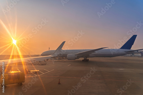 Obraz na płótnie airplane jet waiting to runway on taxi lane in airport and aircraft traffic to take off with sunset background, view from window air plane w salonie