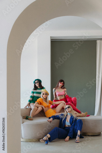 Four fashionable caucasian women wearing stylish colorful outfit